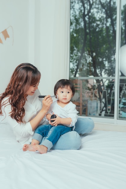 Belle jeune femme et petite fille se maquiller