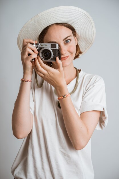 Belle jeune femme photographe avec un chapeau de paille