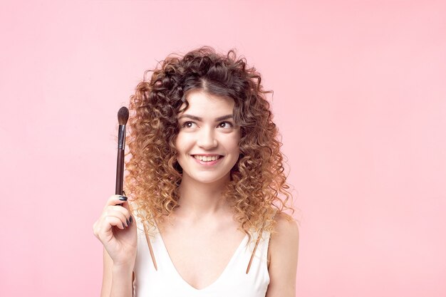 Photo belle jeune femme avec pinceau de maquillage