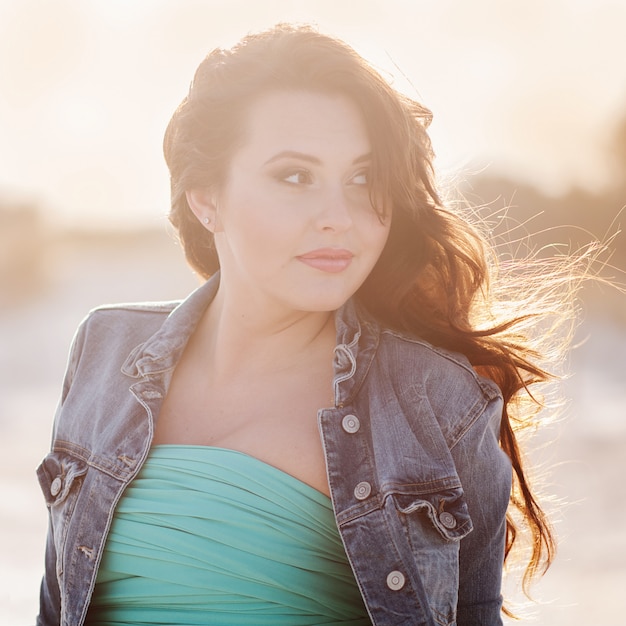 Belle jeune femme sur la plage au coucher du soleil, image extérieure et image tonique