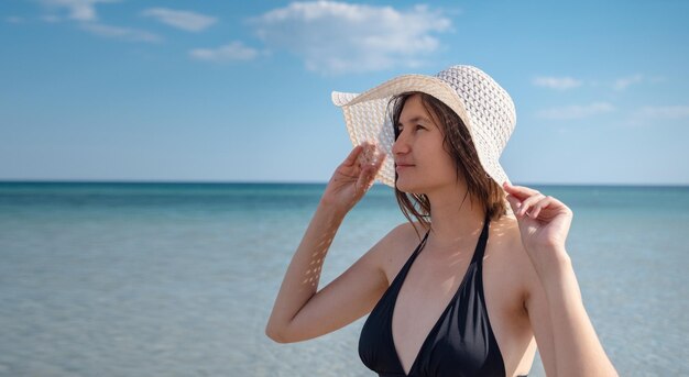 belle jeune femme à la plage portant un chapeau