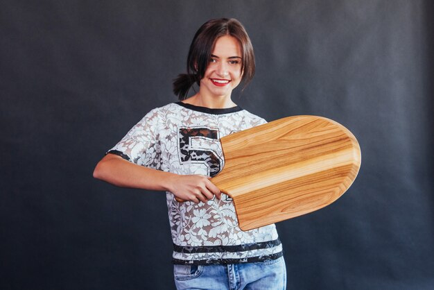 Belle jeune femme avec une planche de bois