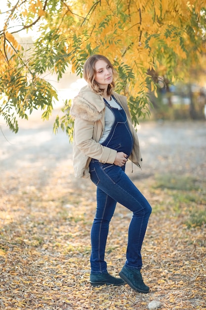 Belle jeune femme en plein air heureuse et enceinte