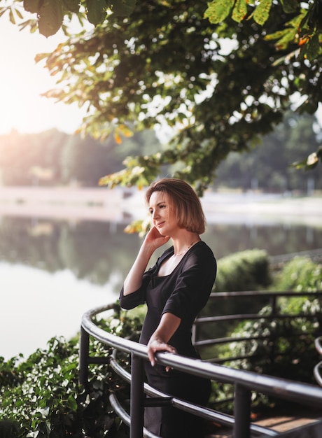 Belle jeune femme portant une robe profitant du lever du soleil sur la rivière dans la vieille ville européenne Mode et style Voyage d'été