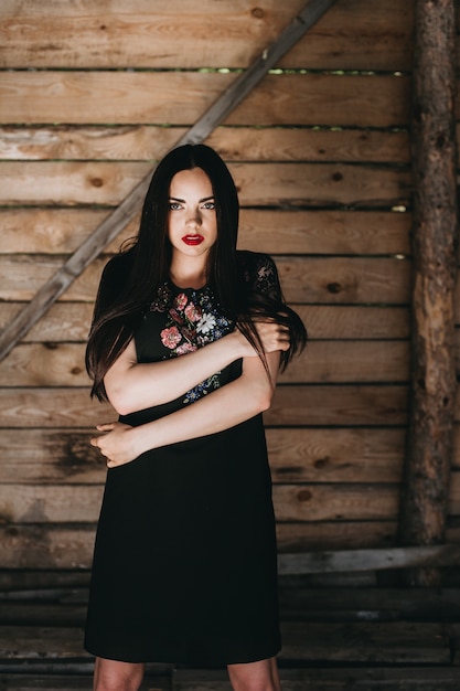 Photo belle jeune femme portant des vêtements nationaux ukrainiens dans une cabane en bois