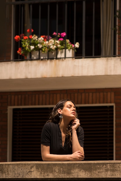 Belle jeune femme posant sur un balcon