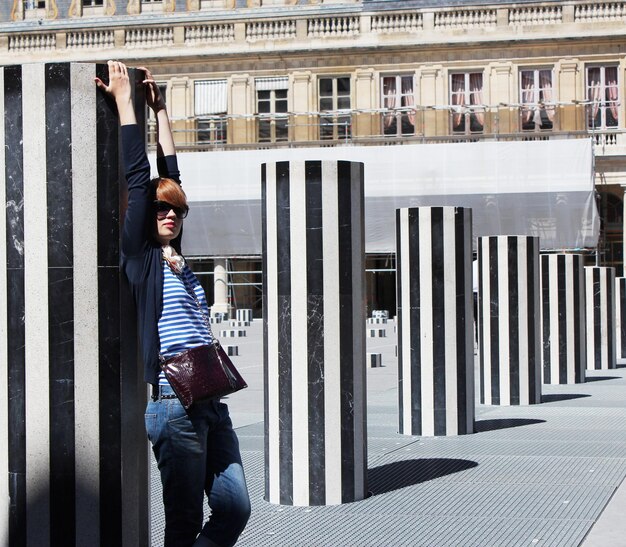 Belle jeune femme posant dans les Colonnes de Buren au Palais Royal à Paris