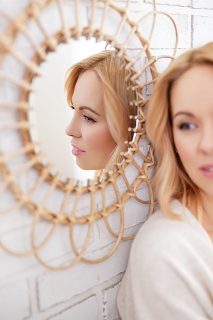 Belle jeune femme posant derrière le miroir