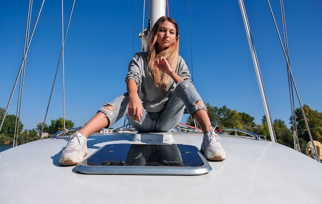 Belle jeune femme posant sur yacht.