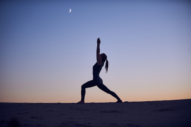 Belle jeune femme pratique le yoga asana Virabhadrasana