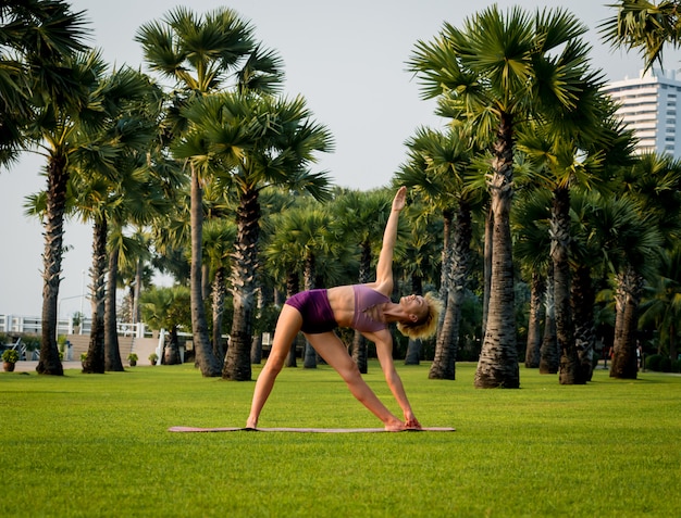 Belle jeune femme pratique le yoga à la plage. Exercice tôt le matin