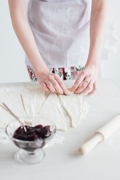 Belle jeune femme prépare des croissants faits maison