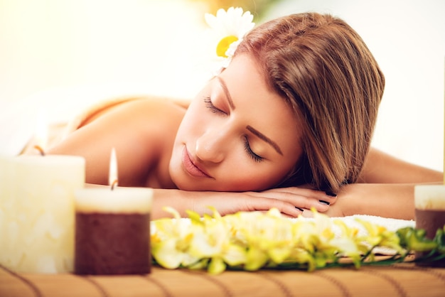 Belle jeune femme profitant d'un soin de la peau dans un spa. Elle se détend les yeux fermés.