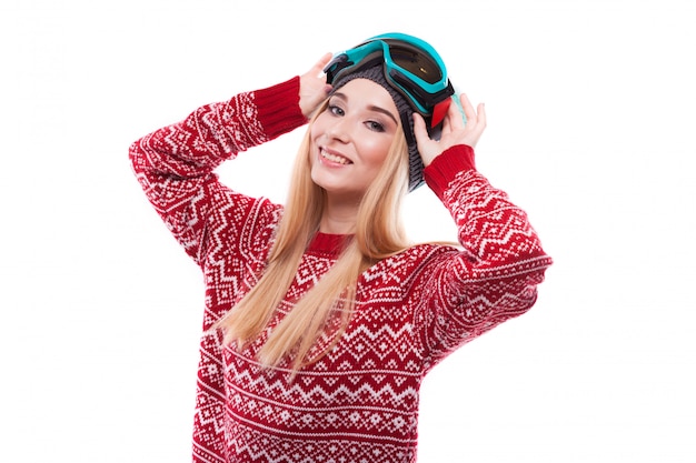 Belle jeune femme en pull rouge et lunettes de ski bleu