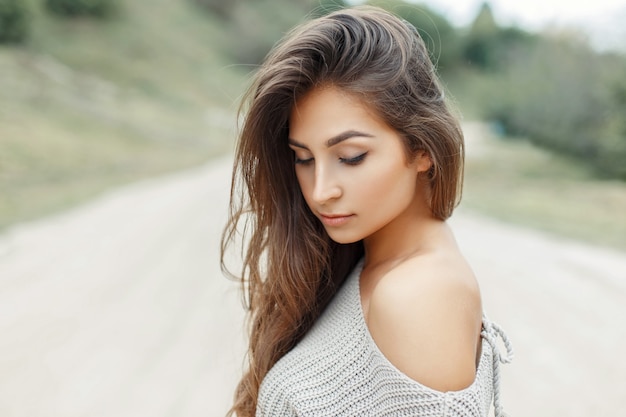 Belle jeune femme en pull tricoté gris