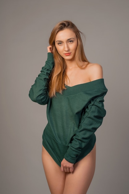 Belle jeune femme qui pose en pull émeraude en studio