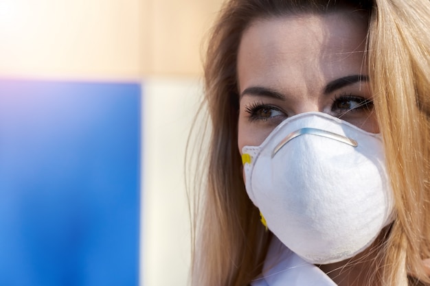 Belle jeune femme de race blanche blonde debout dans un masque de protection