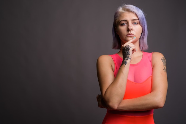 Belle jeune femme rebelle aux cheveux colorés portant une robe rouge néon