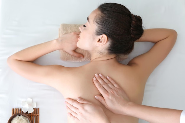 Belle jeune femme recevant un massage dans un salon spa