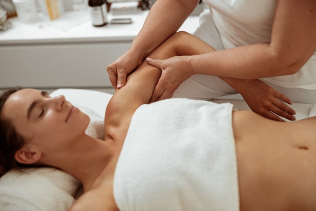 Belle jeune femme recevant un massage professionnel dans un salon spa