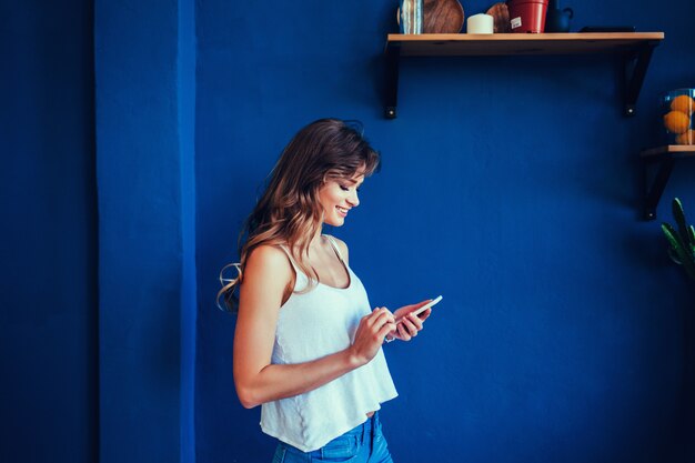 Belle jeune femme regardant son téléphone intelligent