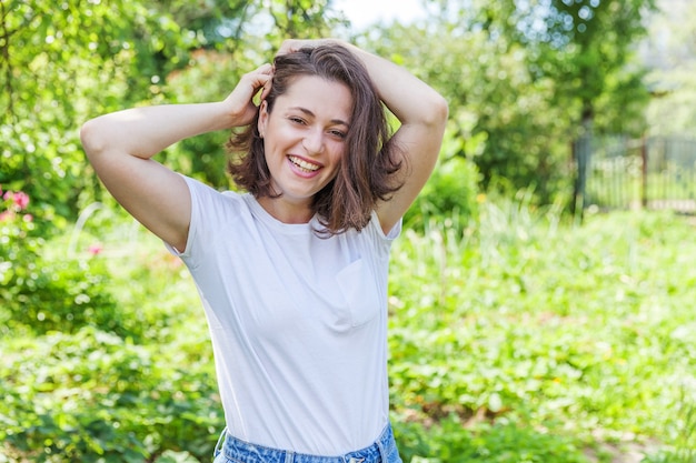 Belle jeune femme reposant sur fond vert parc ou jardin