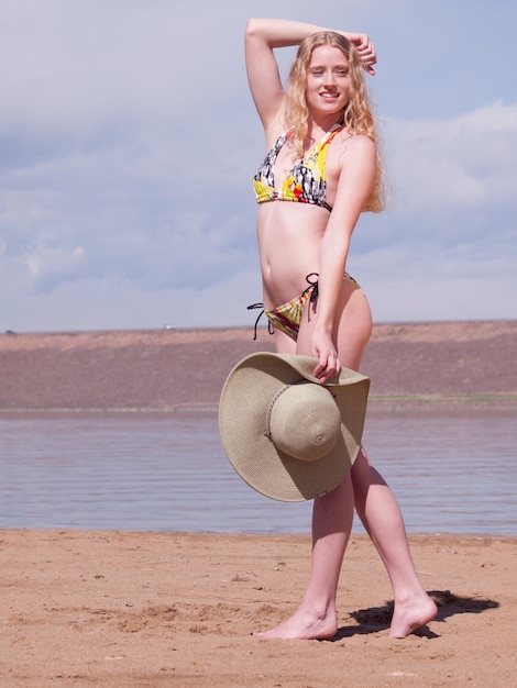 Belle jeune femme reposante sur la plage.