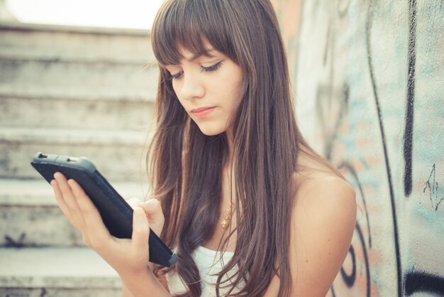 belle jeune femme avec une robe blanche avec tablette