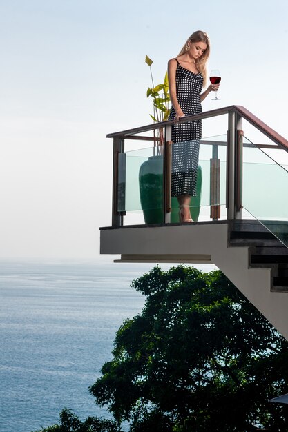 Photo belle jeune femme en robe longue avec verre