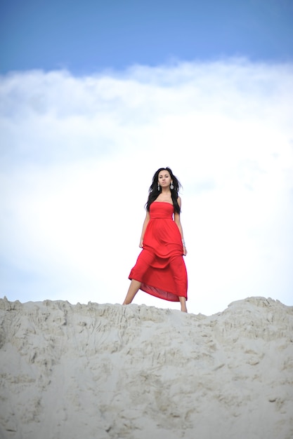 Belle jeune femme en robe rouge sur fond de nature