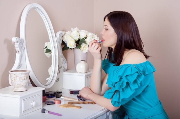 Belle jeune femme avec une robe se maquiller