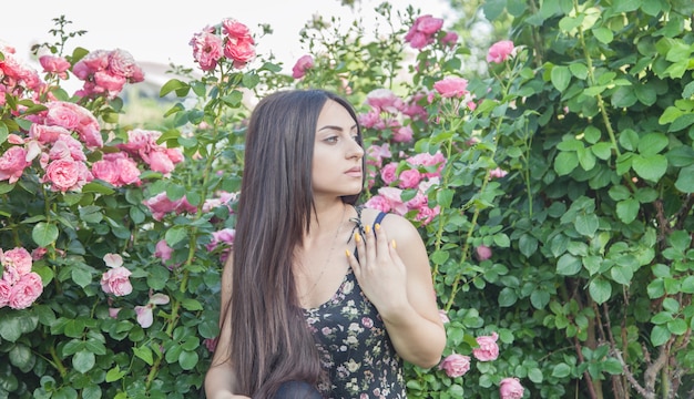 Belle jeune femme avec des roses roses.