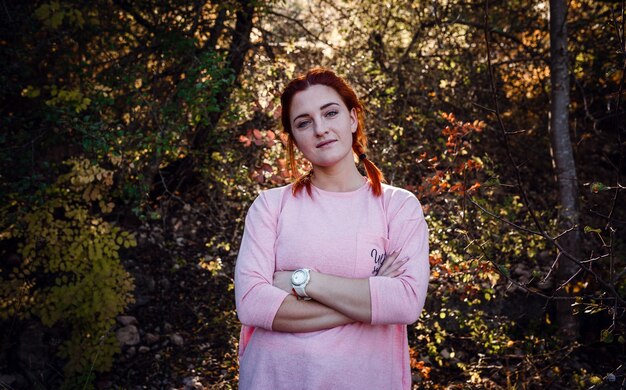 Belle jeune femme rousse dans la forêt d'automne. idée et concept de temps libre, de bonheur, de soins et de liberté, d'activités de plein air et d'un mode de vie sain