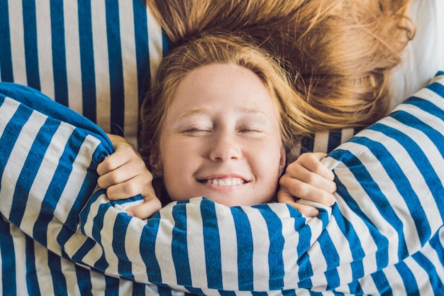 Belle jeune femme s'est réveillée en gros plan de lit.