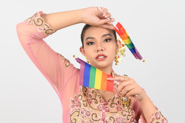 Belle jeune femme s'habille dans la culture locale dans la région sud avec le drapeau arc-en-ciel