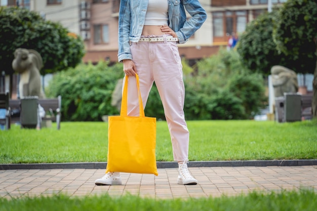 Belle jeune femme avec un sac écologique en lin sur fond de ville
