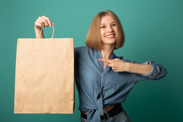 Photo belle jeune femme avec un sac en papier à la main