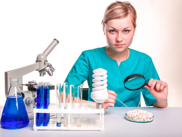 Photo belle jeune femme scientifique travaillant dans un laboratoire avec un microscope.