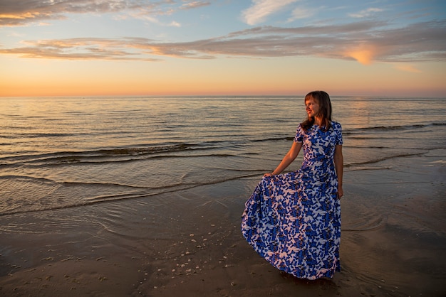 Photo belle jeune femme se détendre au coucher du soleil