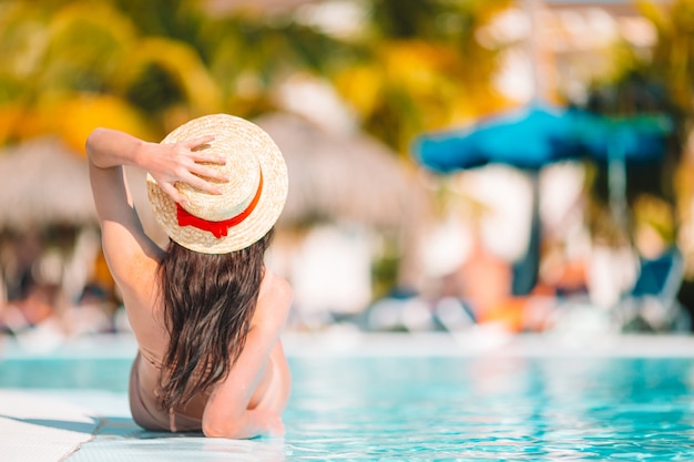 Belle jeune femme se détendre dans la piscine.