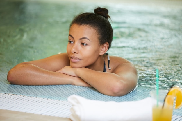 Belle jeune femme se détendre dans la piscine