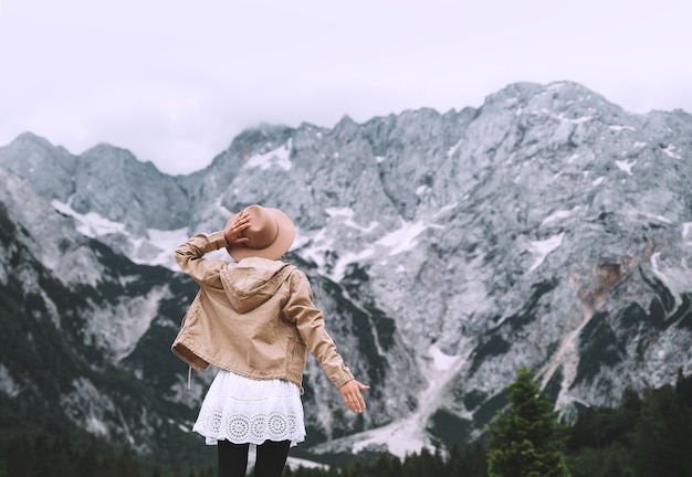 Belle jeune femme se dresse sur fond de montagnes