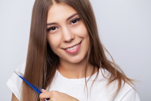 Belle jeune femme se peignant les cheveux dans le salon.