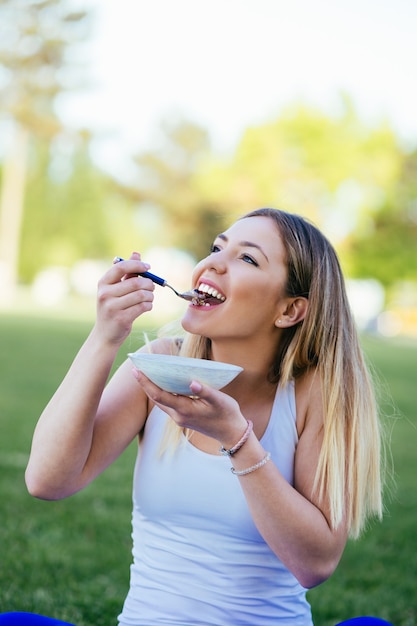 Belle jeune femme séduisante mangeant un repas de désintoxication sain à l'extérieur. Concept de mode de vie sain.