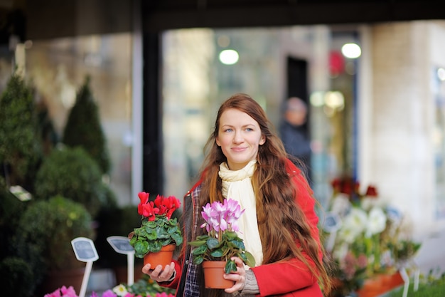 Belle jeune femme en sélectionnant des fleurs fraîches au marché parisien