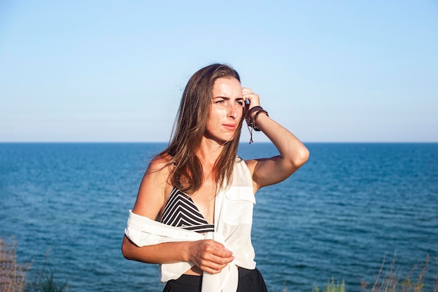 Belle jeune femme sexy posant en se tenant debout sur une falaise.