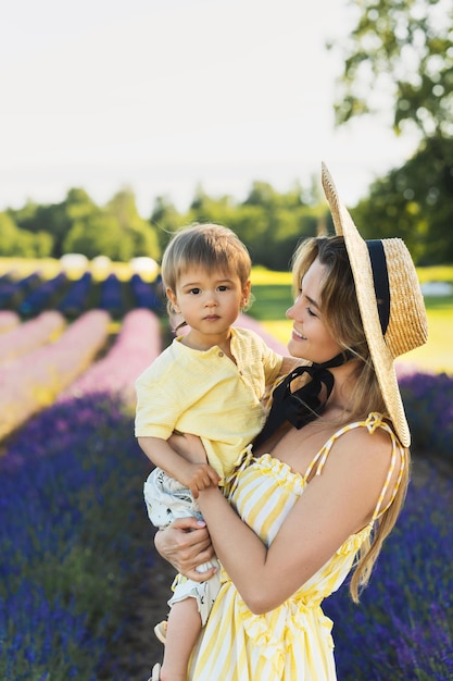 Belle jeune femme et son mignon petit fils dans le champ de lavande