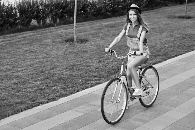 Belle jeune femme avec son vélo au parc