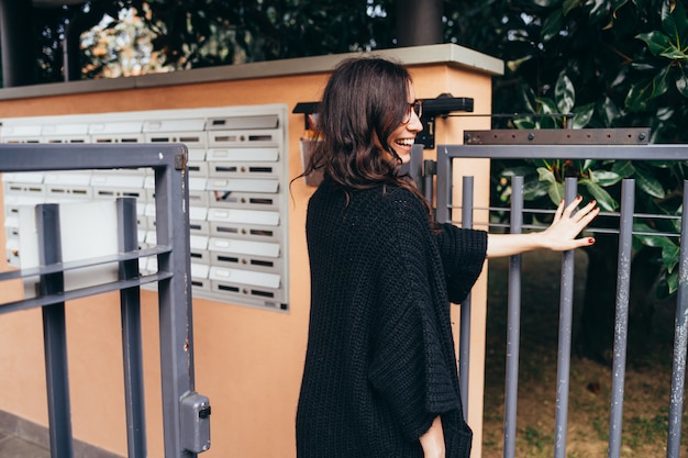 Belle jeune femme sortie extérieure de la porte d'entrée