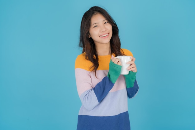 Belle jeune femme souriant joyeusement tout en tenant un verre d'eau à la main